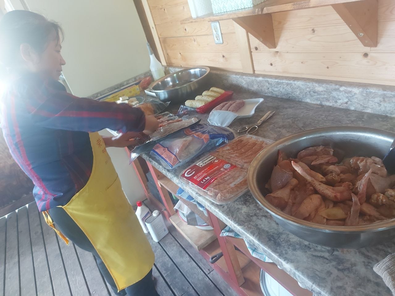 Community members grilling at a screened-in lakeside BBQ house at Lifechanyuan's Canada resort home, ...