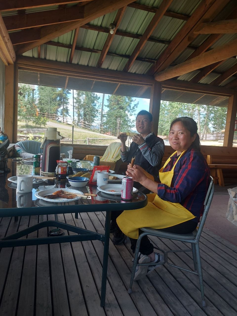 Community members grilling at a screened-in lakeside BBQ house at Lifechanyuan's Canada resort home, ...