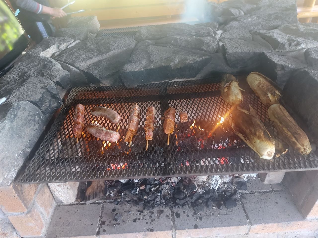 Community members grilling at a screened-in lakeside BBQ house at Lifechanyuan's Canada resort home, ...